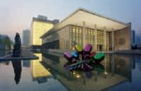 A large fountain with colorful flowers in front of a building.