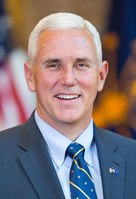 A man in suit and tie smiling for the camera.