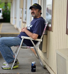 A man sitting in a chair outside of a building.