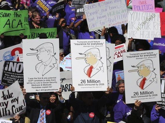 A group of people holding signs with political cartoons.