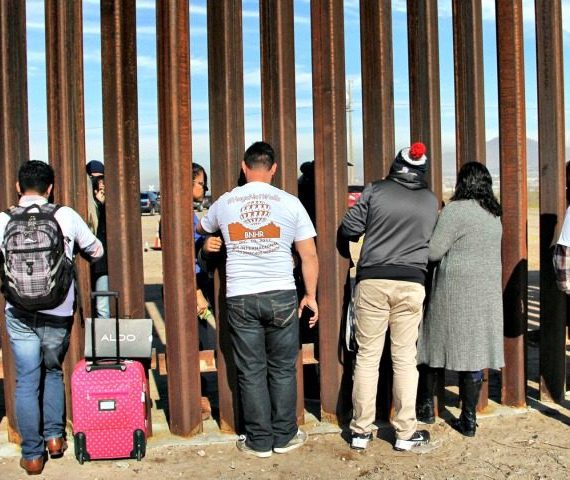 A group of people standing around a wall.