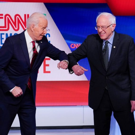 Two men shaking hands on a stage.